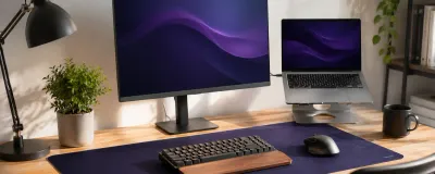 A workspace showing a few affordable desk upgrades: a light bar, a laptop stand, and a desk mat