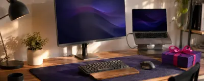 A tidy home office desk with a monitor light bar, desk mat, laptop stand, and a plant as gift ideas