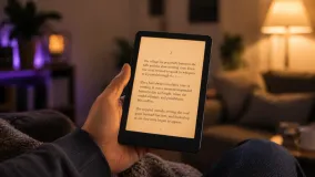 Kindle Paperwhite e-reader showing a page of text, with its warm front light on