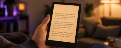 Kindle Paperwhite e-reader showing a page of text, with its warm front light on