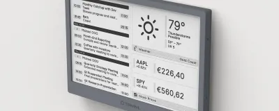 A minimalist workspace featuring a TRMNL E-ink display showing GitHub contributions and weather.