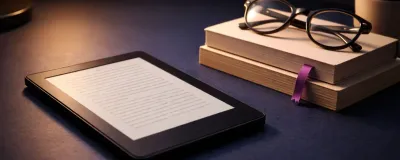 Kindle e-reader on a cozy reading setup with books nearby