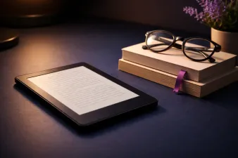 Kindle e-reader on a cozy reading setup with books nearby