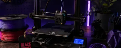 A 3D printer with a Black Friday sale tag and filament spools