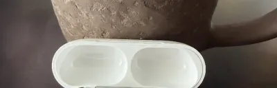 AirPods Pro 3 in their charging case on a modern desk