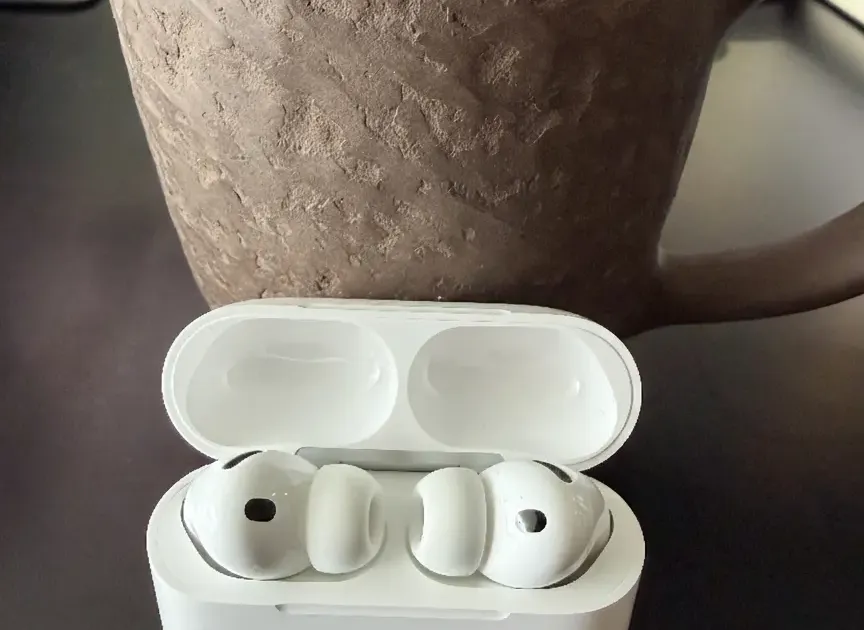 AirPods Pro 3 in their charging case on a modern desk