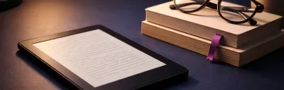 Kindle e-reader on a cozy reading setup with books nearby