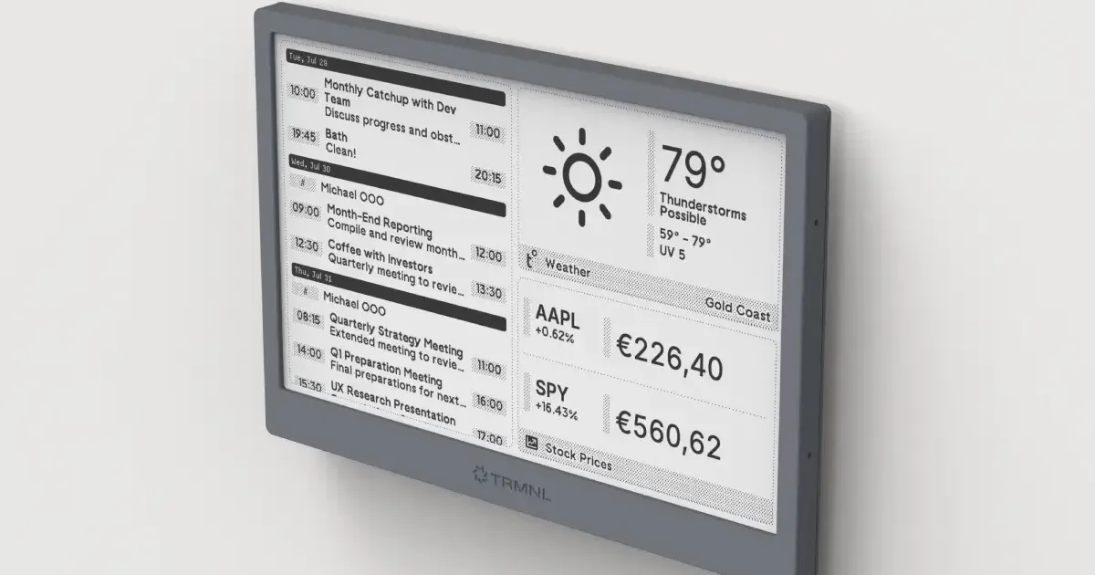 A minimalist workspace featuring a TRMNL E-ink display showing GitHub contributions and weather.